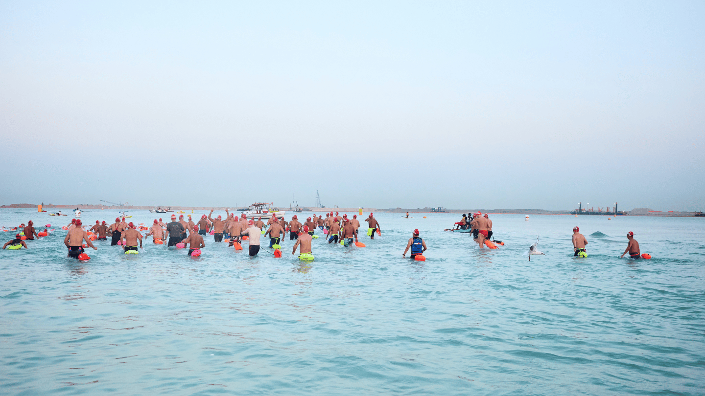 Учасники OCEANMAN World Final Championship 2025 заходять у воду перед стартом запливу в Дубаї